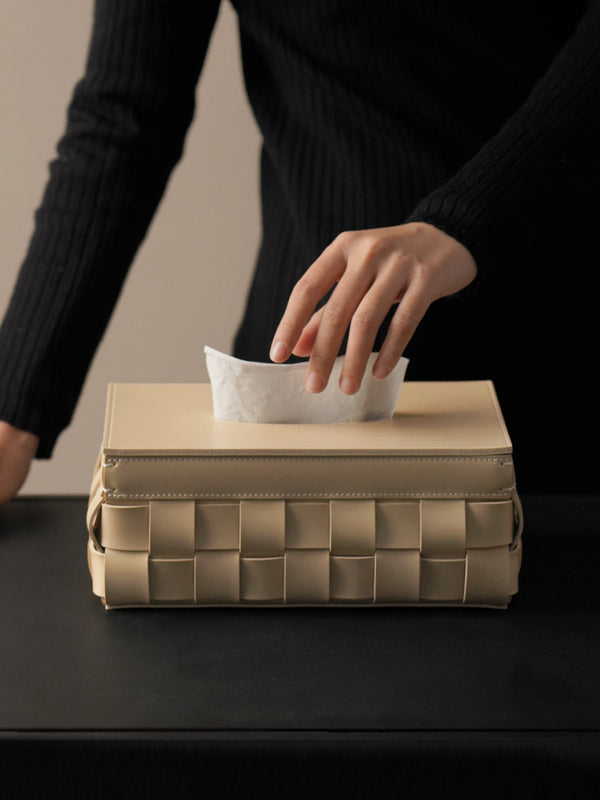 Woman taking tissue from cream leather box. | Kvinna tar näsduk från krämig lädernäsduksask