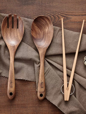 Set of wooden serving spoon and spork on wooden background. | Set träserveringssked och gaffel-sked på träbakgrund.