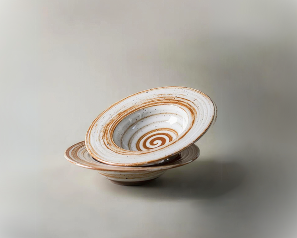 A stack of two rustic ceramic plates with a swirled pattern, set against a plain background with the Aphrodite's Casa logo at the top