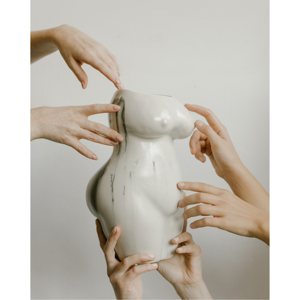 Two hands curving around a green vase with striped shadows, artistic flair.