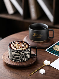 Black coffee cup with cream, on wooden table with sugar. | Svart kaffekopp med grädde, på träbord med socker.
