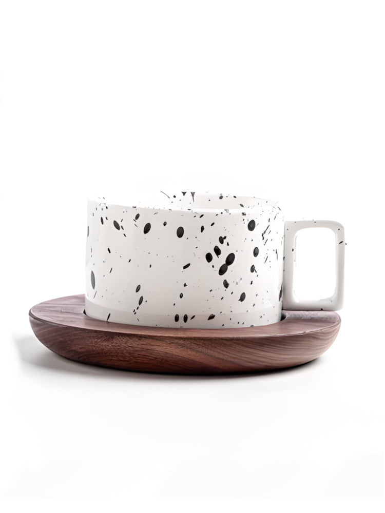 White coffee cup with black sprinkles, wooden tray, white background. | Vit kaffekopp med svarta strössel, träbricka, vit bakgrund.