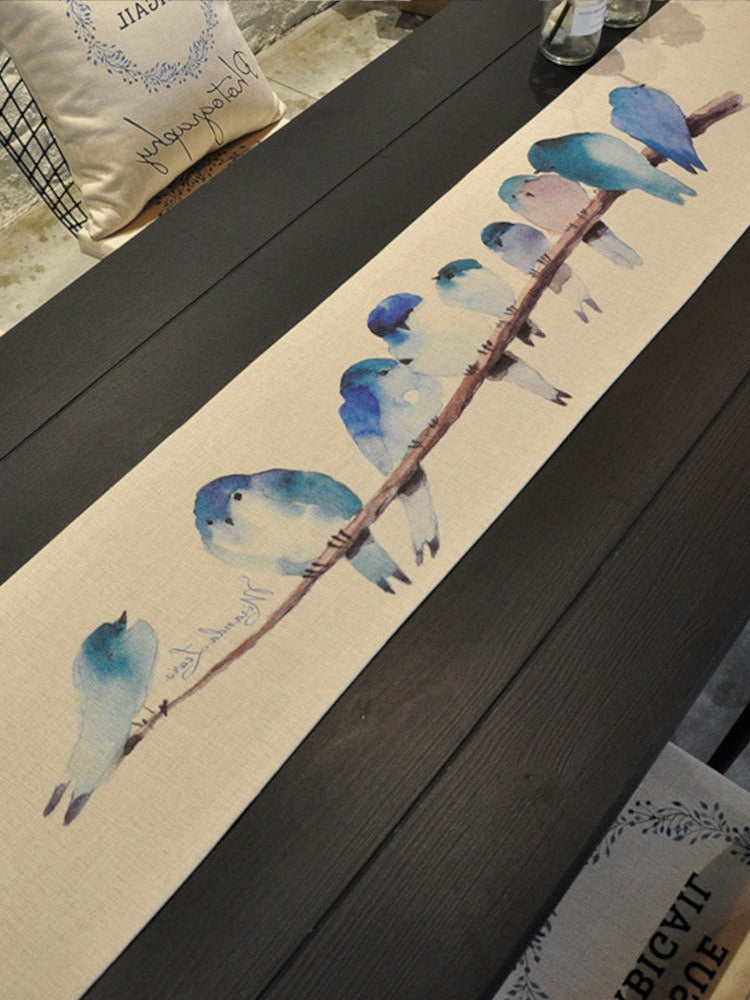 Black table with cream tablerunner, flock of bluebirds. | Svart bord med krämfärgad bordslöpare, flock blåfåglar.