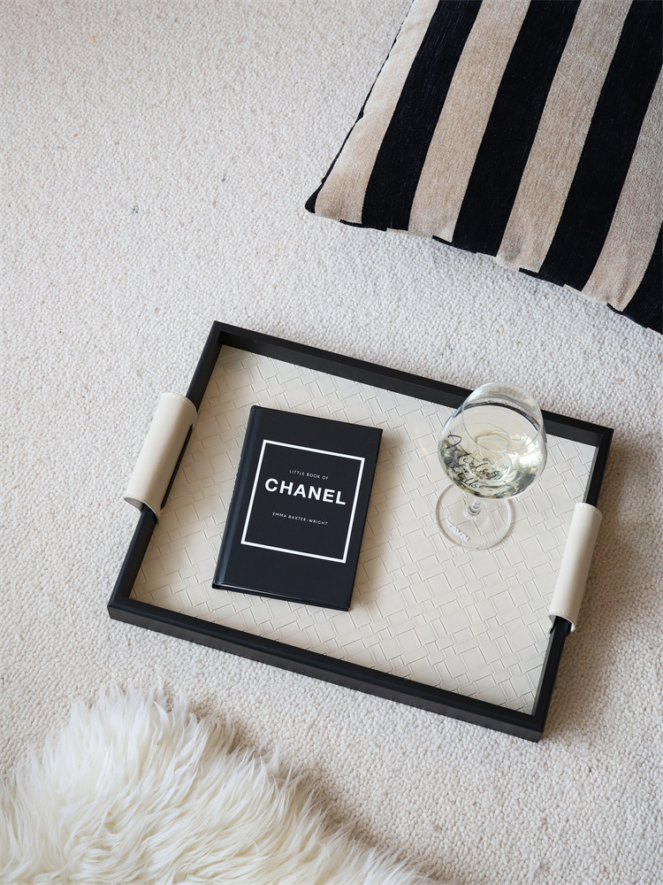 Woven leather tray with wine glass and fashion brochure. | Vävd läderbricka med vinglas och modemagasin.