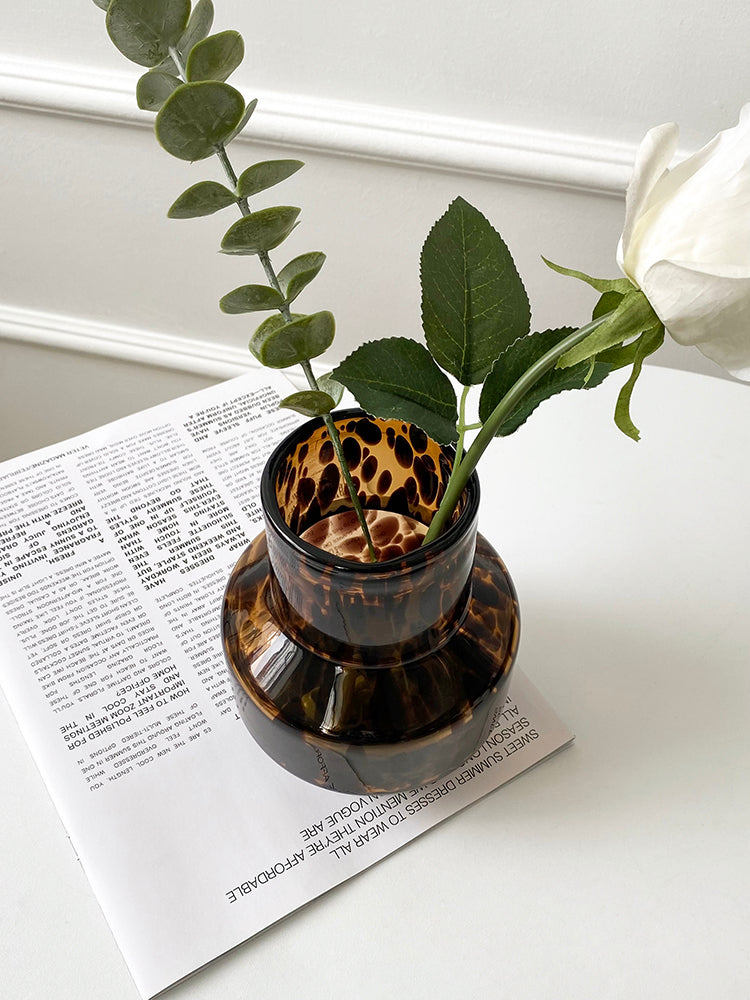 Small glass vase, leopard texture, aerial view with rose. | Liten glasvas, leopardtextur, vy uppifrån med ros.