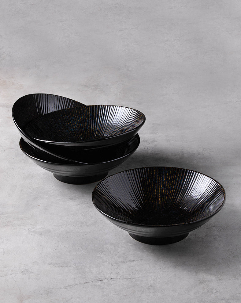 Pair of black bowls on grey backdrop." | Svarta skålar på grå bakgrund.