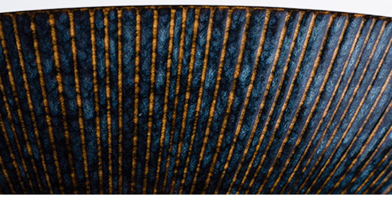 Intricate blue and bronze striped bowl." | Blå & bronsmönstrad skål.