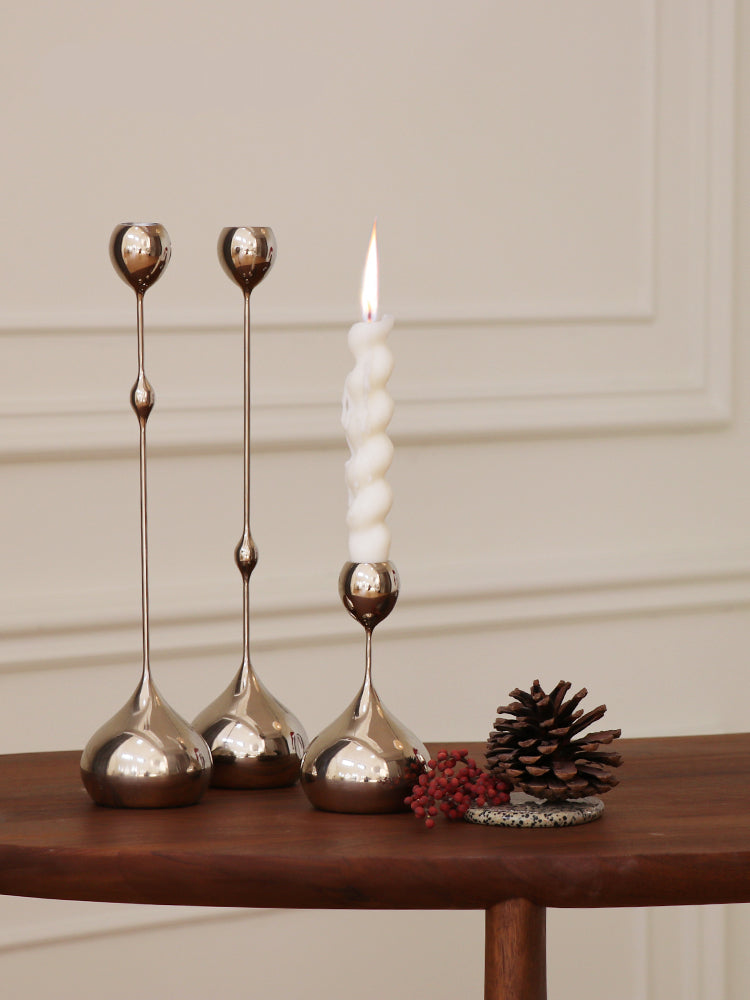Three silver candlesticks, wooden table, festive and elegant. | Tre silverljusstakar, träbord, festlig och elegant.