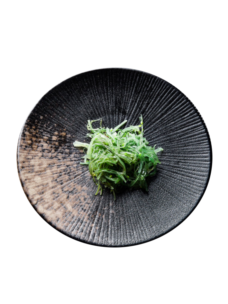  Textured black plate, vibrant seaweed, rustic wooden table. | Texturerad svart tallrik, levande sjögräs, rustikt träbord.