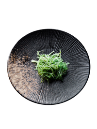  Textured black plate, vibrant seaweed, rustic wooden table. | Texturerad svart tallrik, levande sjögräs, rustikt träbord.