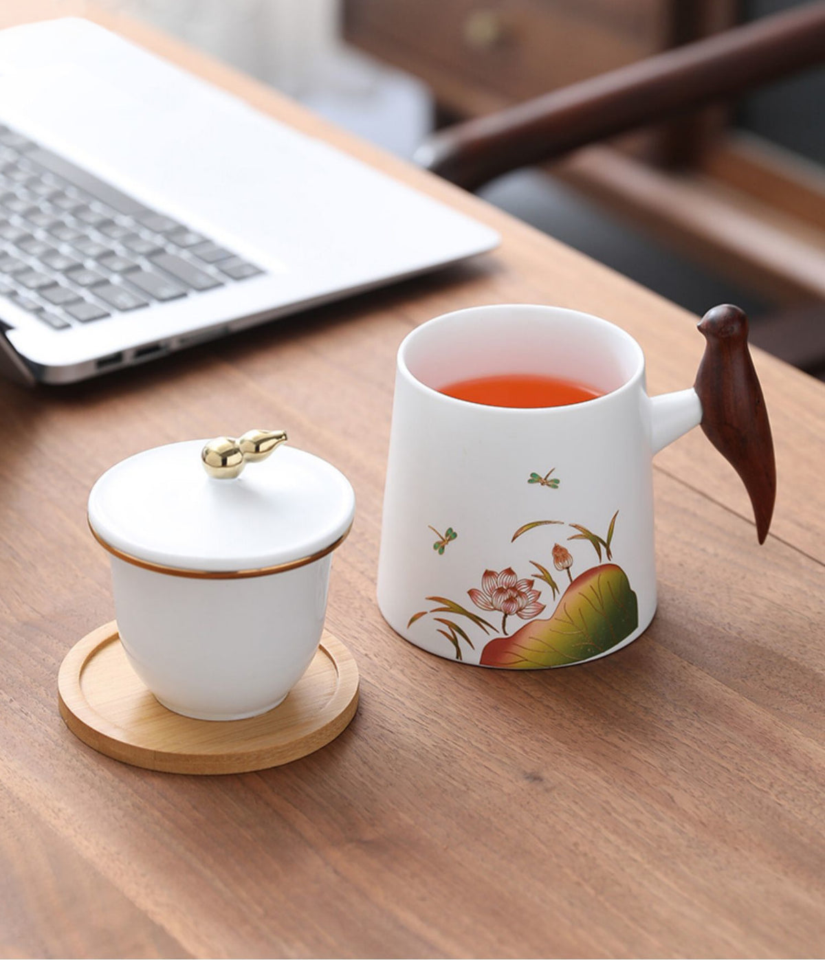 White cups with tea inside, wooden magpie handles. | Vita koppar med te, träskatthandtag.