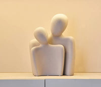 White ceramic ornament, male and female silhouette hugging. | Vit keramikprydnad, manlig och kvinnlig siluett kramas.