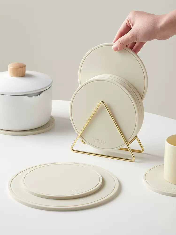 Set of white table mats stacked in golden triangle. | Set vita bordsmattor staplade i gyllene triangel.