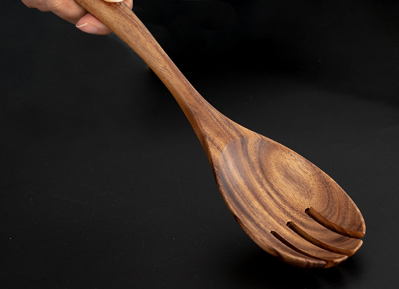 Close-up front of wooden serving spork on wooden table. | Närbild framifrån av träservering gaffel-sked på träbord.
